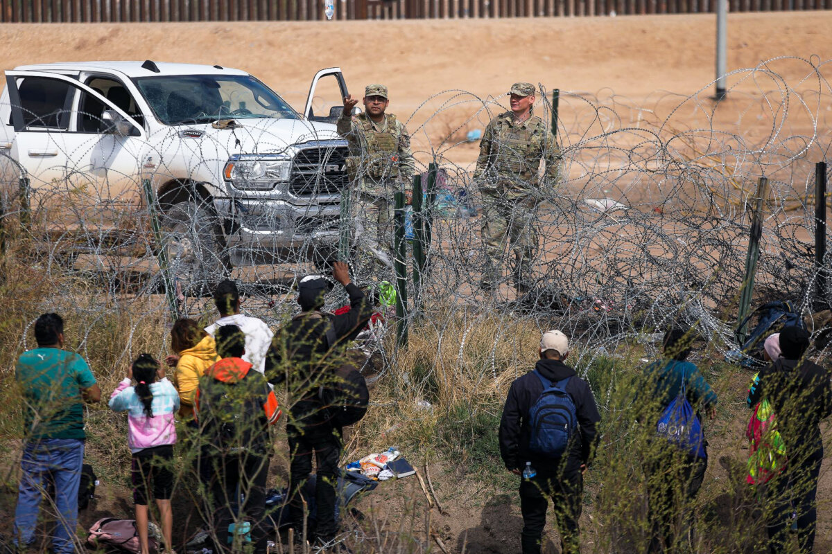 Các nhân viên của Lực lượng Vệ binh Quốc gia Texas ngăn chặn những người nhập cư bất hợp pháp từ Venezuela vượt qua hàng rào thép gai ở Biên giới Khu vực El Paso sau khi băng qua Rio Grande từ Ciudad Juarez, bang Chihuahua, Mexico, hôm 29/02/2024. (Ảnh: Herika Martinez/AFP qua Getty Images)