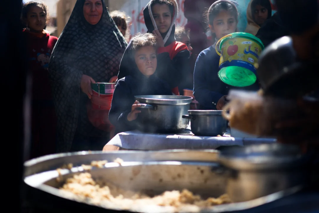 Trẻ em Palestine chờ nhận thức ăn do một bếp từ thiện nấu trong bối cảnh thiếu nguồn cung cấp thực phẩm, khi cuộc chiến đang diễn ra giữa Israel và Hamas vẫn tiếp diễn, tại Rafah, phía nam Dải Gaza, hôm 05/03/2024. (Ảnh: Mohammed Salem/Reuters)
