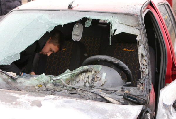 Một người dân kiểm tra một chiếc xe hơi bị hỏng do trúng pháo kích trong điều mà chính quyền địa phương gọi là cuộc tấn công của quân đội Ukraine vào vùng Belgorod phía tây của Nga, hôm 19/03/2024. (Ảnh: Stringer/Reuters)
