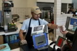 Một nhân viên thu ngân tại một cửa hàng bán bánh Pretzel và Cinnabon của chuỗi nhà hàng Auntie Anne's ở Livermore, California, vào hôm 28/03/2024. (Ảnh: Terry Chea/AP Photo)