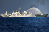 Một tàu Hải cảnh Trung Quốc phun vòi rồng vào Unaizah, một tàu thuê của Hải quân Philippines, đang thực hiện nhiệm vụ tiếp tế thường lệ cho các binh sĩ đóng tại Bãi cạn Thomas thứ Hai (Bãi Cỏ Mây), trên Biển Đông, hôm 05/03/2024. (Ảnh: Ezra Acayan/Getty Images)