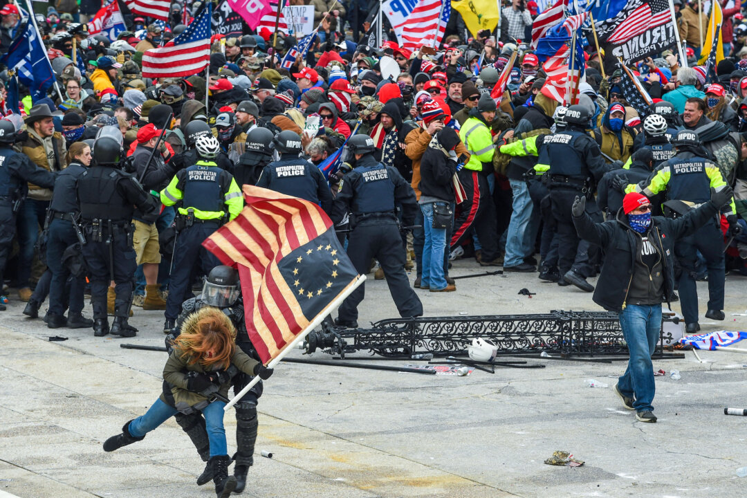 Cảnh sát cố gắng ngăn cản những người biểu tình ở West Plaza của Tòa nhà Quốc hội Hoa Kỳ vào ngày 06/01/2021. (Ảnh: Roberto Schmidt/AFP qua Getty Images)