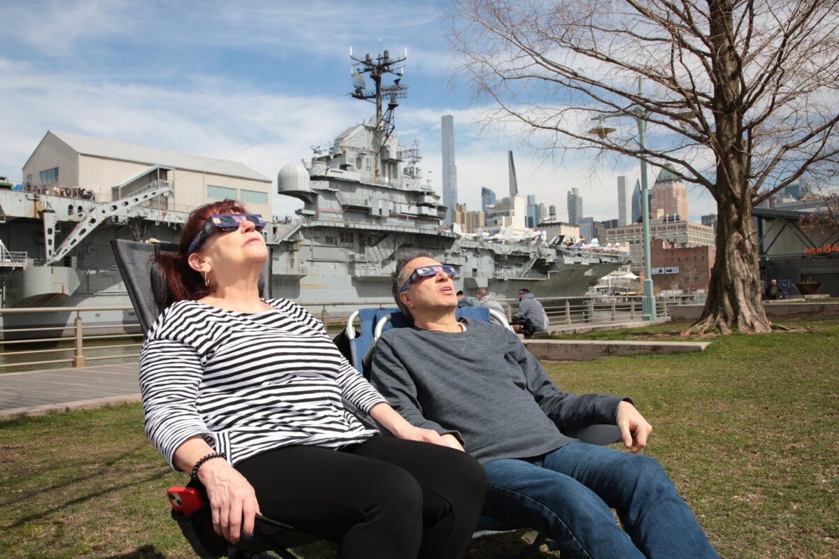 Bà Holly và ông Antone ngồi xem hiện tượng nhật thực, trên đường Pier 84 tại Công viên Sông Hudson, New York, hôm 08/04/2024. (Ảnh: Richard Moore/The Epoch Times)