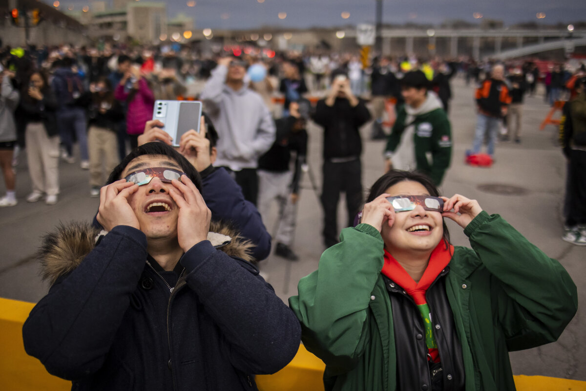 Du khách xem hiện tượng nhật thực toàn phần bằng kính đặc biệt, ở thành phố Niagara Falls, Ontario, hôm 08/04/2024. (Ảnh: Richard Moore/The Epoch Times)