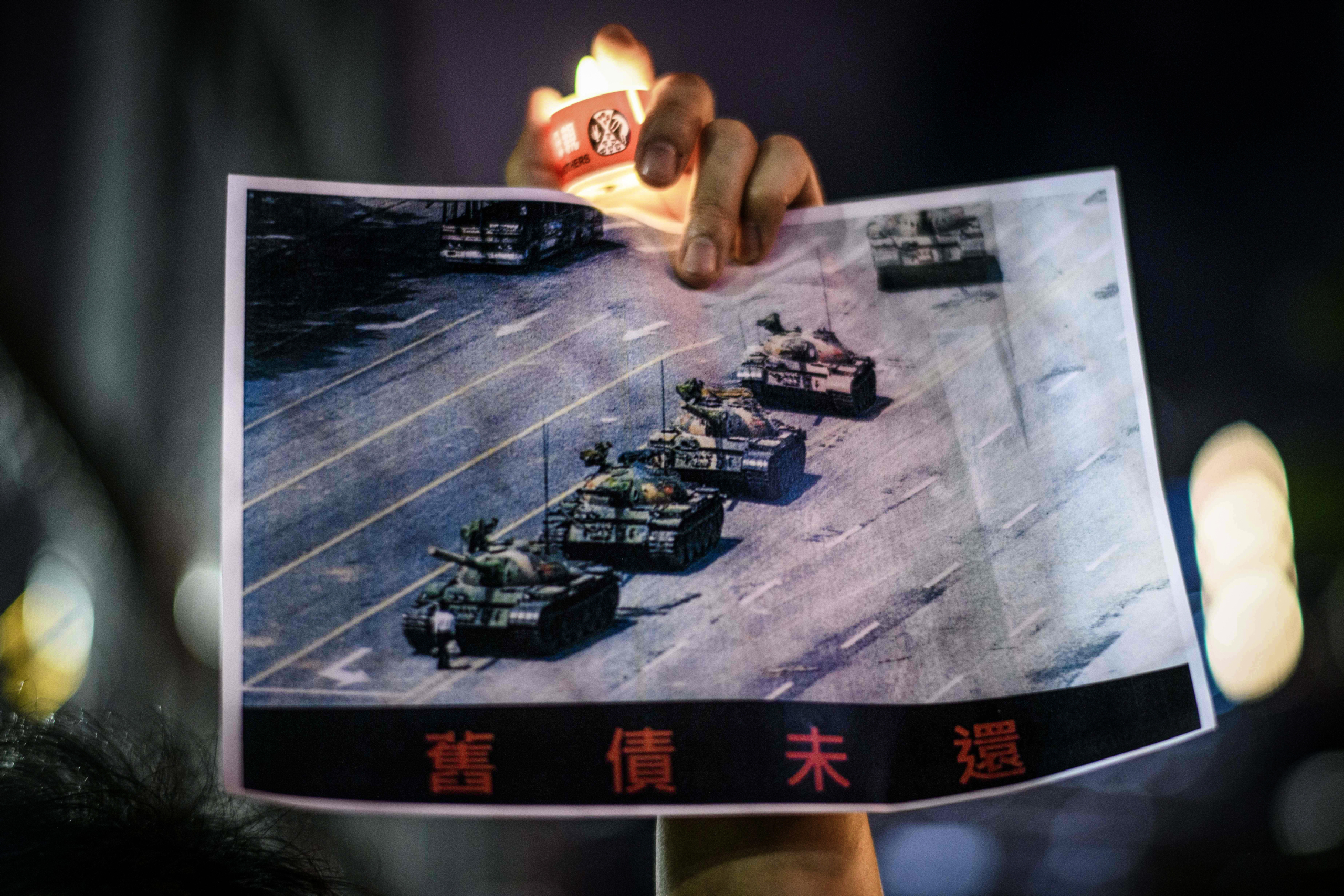 Một người đàn ông cầm tấm bích chương hình “Tank Man” nổi tiếng, chụp cảnh một người đàn ông đang đứng trước xe tăng quân sự Trung Quốc tại Quảng trường Thiên An Môn ở Bắc Kinh vào ngày 05/06/1989, trong lễ tưởng niệm sự kiện Quảng trường Thiên An Môn năm 1989, tại Công viên Victoria ở Hồng Kông, vào ngày 04/06/2020. (Ảnh: Anthony Wallace/AFP qua Getty Images)
