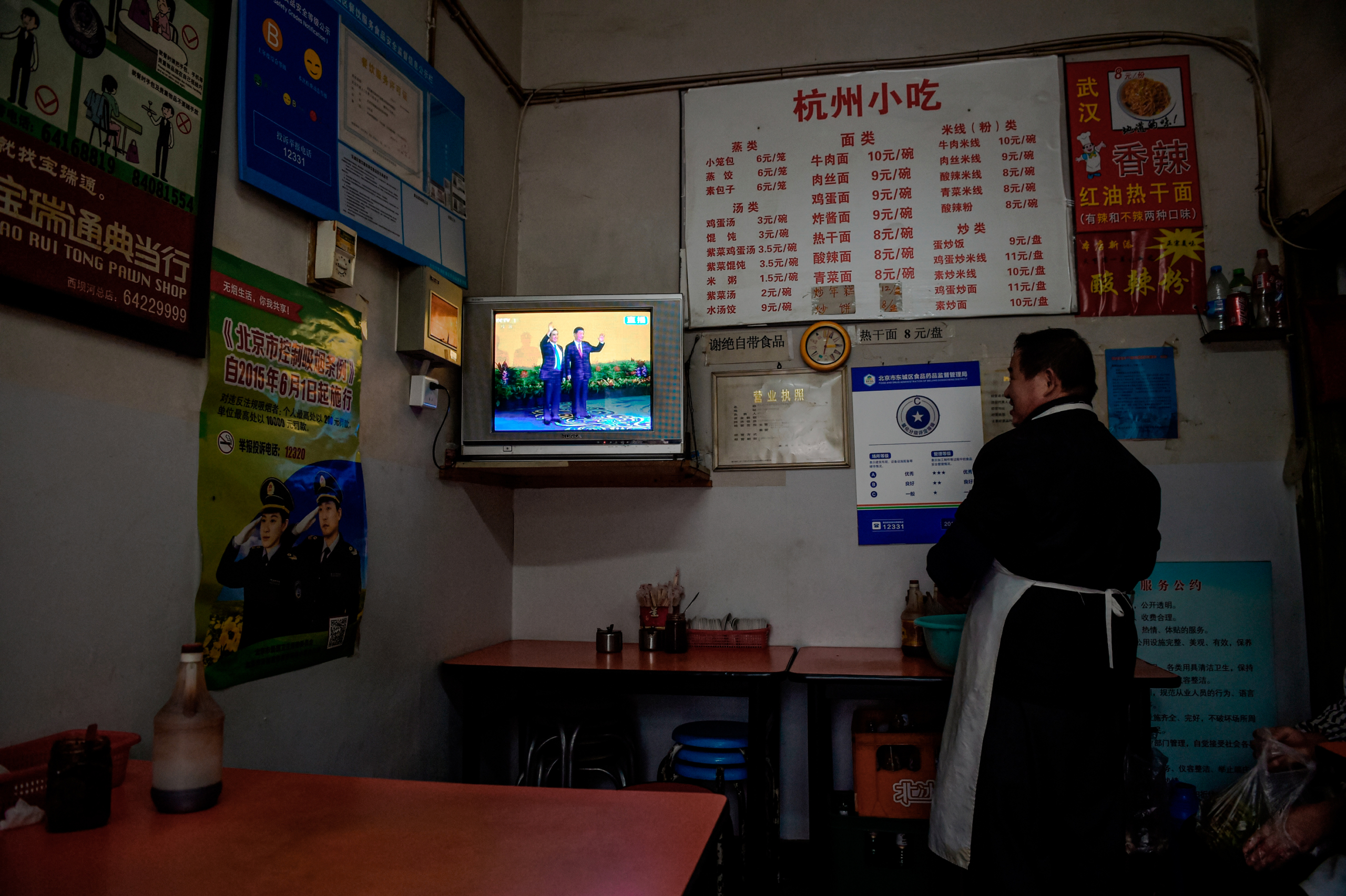 Một chủ nhà hàng xem truyền hình trực tiếp cuộc gặp ở Bắc Kinh giữa lãnh đạo Trung Quốc Tập Cận Bình và cựu Tổng thống Đài Loan Mã Anh Cửu, tại Singapore, vào ngày 07/11/2015. (Ảnh: Greg Baker/AFP qua Getty Images)