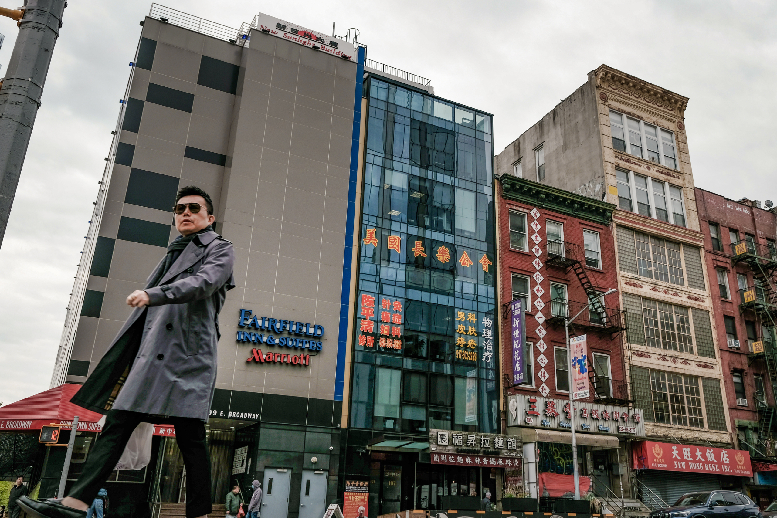 Một người đàn ông đi ngang qua một tòa nhà (ở giữa) bị nghi ngờ là đồn công an chìm do Bắc Kinh kiểm soát dùng để đàn áp những người bất đồng chính kiến đang sống ở Hoa Kỳ, tại khu phố người Hoa của thành phố New York hôm 18/04/2023. (Ảnh: Spencer Platt/Getty Images)