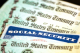 Thẻ An sinh Xã hội cạnh những tấm chi phiếu từ Bộ Ngân khố Hoa Kỳ ở Hoa Thịnh Đốn hôm 14/10/2021. (Ảnh: Kevin Dietsch/Getty Images)