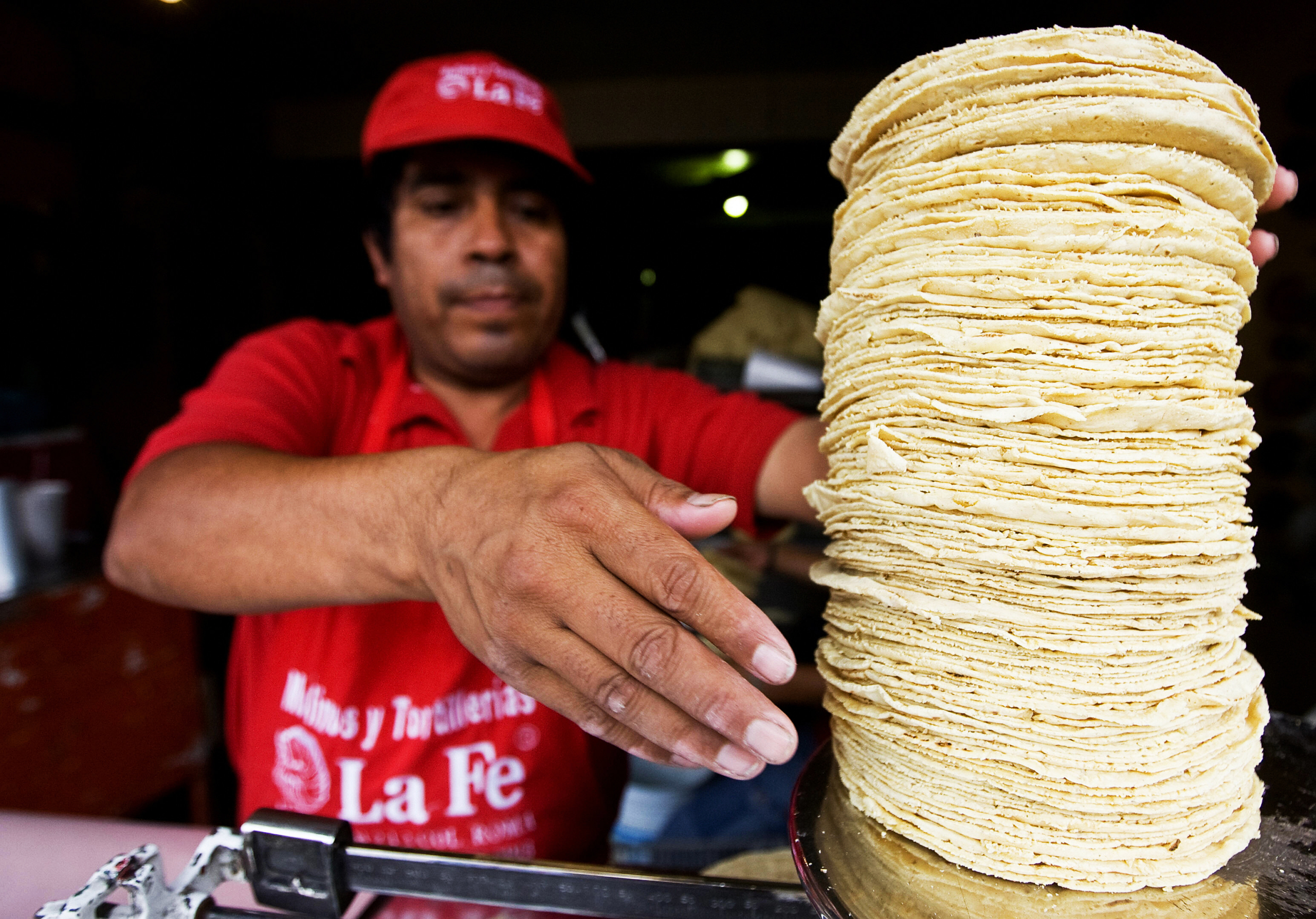 Một người bán hàng rong cân những chiếc bánh bắp truyền thống ở Mexico, vào ngày 18/06/2008. Sự phổ biến của bắp trong các bữa ăn ở Mexico khiến tỷ lệ tiếp xúc với bắp biến đổi gene và glyphosate tăng lên. (Ảnh: Ronaldo Schemidt/AFP qua Getty Images)