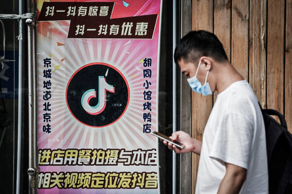 Một người đàn ông đi ngang qua một nhà hàng có logo TikTok hiển thị trên cửa sổ ở Bắc Kinh hôm 14/09/2020. (Ảnh: Greg Baker/AFP qua Getty Images)