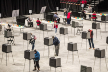 Cử tri tiến hành điền thông tin và bỏ phiếu tại địa điểm bỏ phiếu Trung tâm Bảo hiểm Cross, nơi toàn thành phố bỏ phiếu ở Bangor, Maine, vào ngày 03/11/2020. (Ảnh: Scott Eisen/Getty Images)