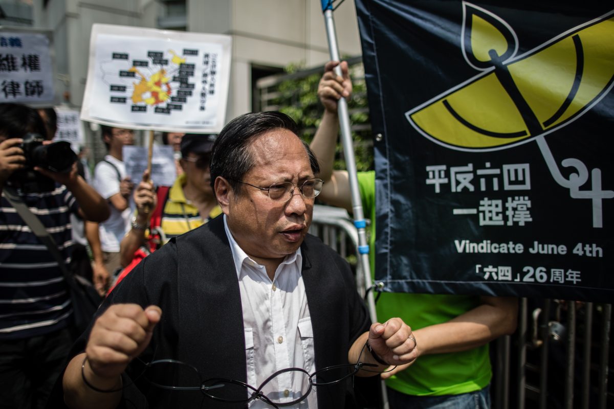 Ông Albert Ho (ở giữa) thuộc Đảng Dân Chủ Hồng Kông đeo còng tay giả khi tham dự một cuộc biểu tình sau khi có ít nhất 50 luật sư và nhà hoạt động nhân quyền Trung Quốc bị giam giữ hoặc thẩm vấn những ngày trước đó trong một cuộc đột kích “chưa từng có” của cảnh sát. Tại Hồng Kông vào ngày 12/07/2015. (Ảnh: Anthony Wallace/AFP/Getty Images)