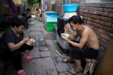 Người ăn tối trên đường phố trong một làng di cư ở vùng ngoại ô Bắc Kinh, ngày 17/08/2017. (Ảnh: Nicolas Asfouri/AFP/Getty Images)