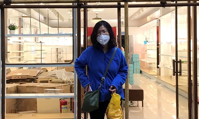 Cô Trương Triển (Zhang Zhan) đứng gần một giàn giáo bên ngoài một cửa hàng trong chuyến thăm Vũ Hán ở tỉnh Hồ Bắc, Trung Quốc, vào ngày 11/04/2020. (Ảnh: Melanie Wang qua AP)