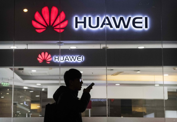 Một người đi bộ nói chuyện điện thoại khi đi ngang qua cửa hàng của Huawei Technologies Co. ở Bắc Kinh, Trung Quốc, vào ngày 29/01/2019. (Ảnh: Kevin Frayer/Getty Images)