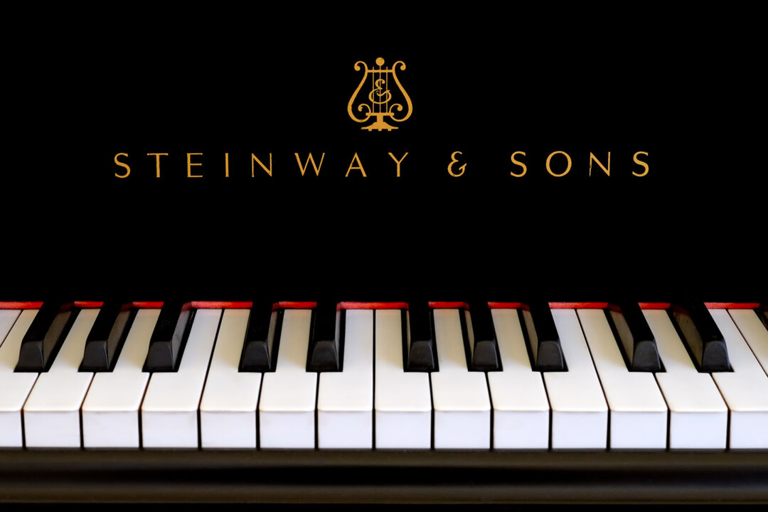 Chữ vàng cổ điển nằm phía trên các phím đàn của cây đại dương cầm Steinway màu đen tuyền. (Ảnh: cdrin/Shutterstock)