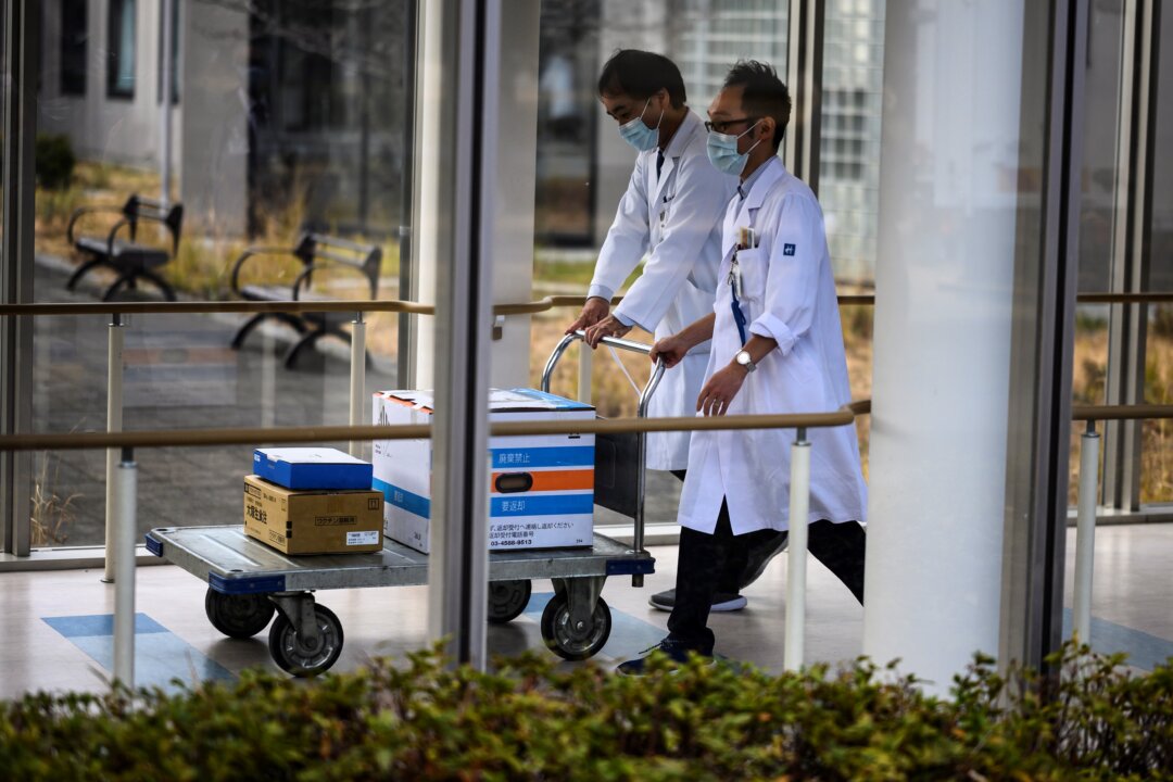 Các nhân viên y tế đẩy xe chở các hộp chứa vaccine COVID-19 khi Nhật Bản khai triển chiến dịch chích ngừa tại Bệnh viện Quốc gia Tokyo ở Kiyose, quận Tokyo, vào ngày 17/02/2021. (Ảnh: Charly Triballeau/AFP qua Getty Images)