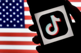 Trong ảnh minh họa này, biểu tượng ứng dụng mạng xã hội TikTok được hiển thị trên màn hình iPhone với nền phía sau là cờ Mỹ quốc ở Arlington, Virginia vào ngày 03/08/2020. (Ảnh: Olivier Douliery/AFP qua Getty Images)