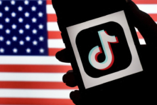 Logo của ứng dụng mạng xã hội TikTok hiển thị trên màn hình một chiếc iPhone trên nền quốc kỳ Mỹ ở Arlington, Virginia, ngày 03/08/2020. (Ảnh: Olivier Douliery/AFP qua Getty Images)