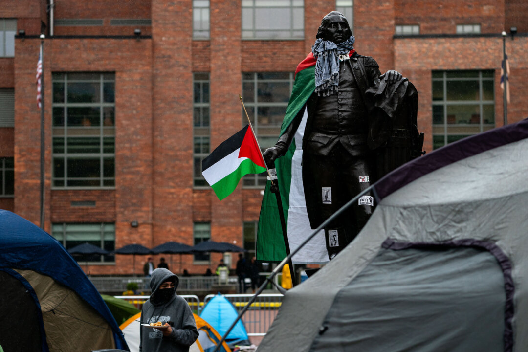 Tượng đài cựu tổng thống George Washington đang được khoác cờ Palestine và choàng khăn keffiyeh trong bối cảnh các nhà hoạt động và sinh viên biểu tình gần một khu cắm trại tại Sân Đại học thuộc Đại học George Washington, ở Thủ đô Hoa Thịnh Đốn, hôm 27/04/2024. (Ảnh: Kent Nishimura/Getty Images)