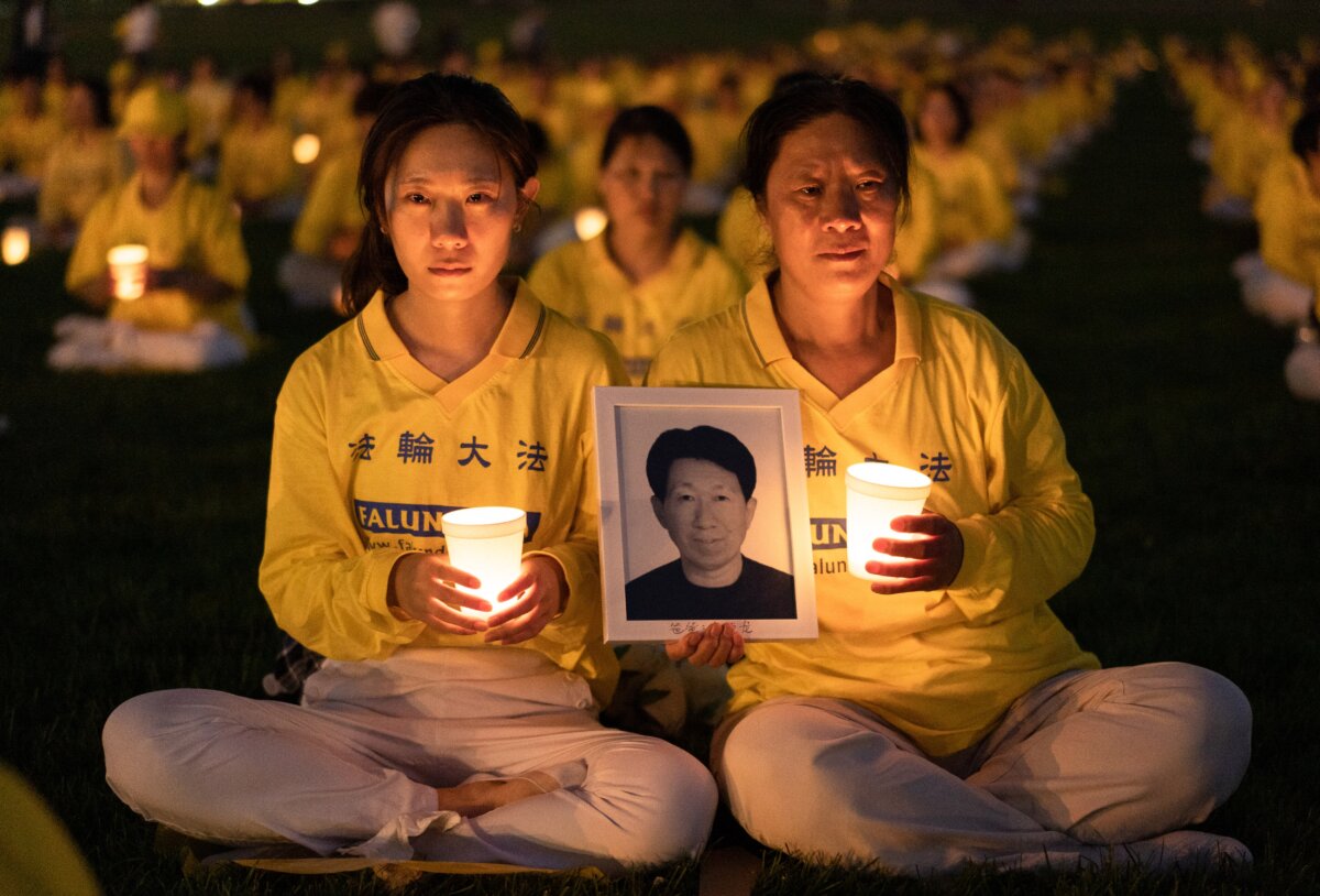 Cô Lý Tiểu Hoa (Li Xiaohua) cùng mẹ cô là bà Cư Thụy Hồng (Ju Reihjong) tham dự buổi thắp nến tưởng niệm để tưởng nhớ các nạn nhân trong cuộc bức hại Pháp Luân Công kéo dài 23 năm ở Trung Quốc, được tổ chức tại Đài tưởng niệm Washington hôm 21/07/2022. Bà Cư cầm di ảnh của chồng bà và cũng là cha của cô Lý, ông Lý Đức Long (Li Delong), người đã thiệt mạng trong cuộc bức hại. (Ảnh: Samira Bouaou/The Epoch Times)
