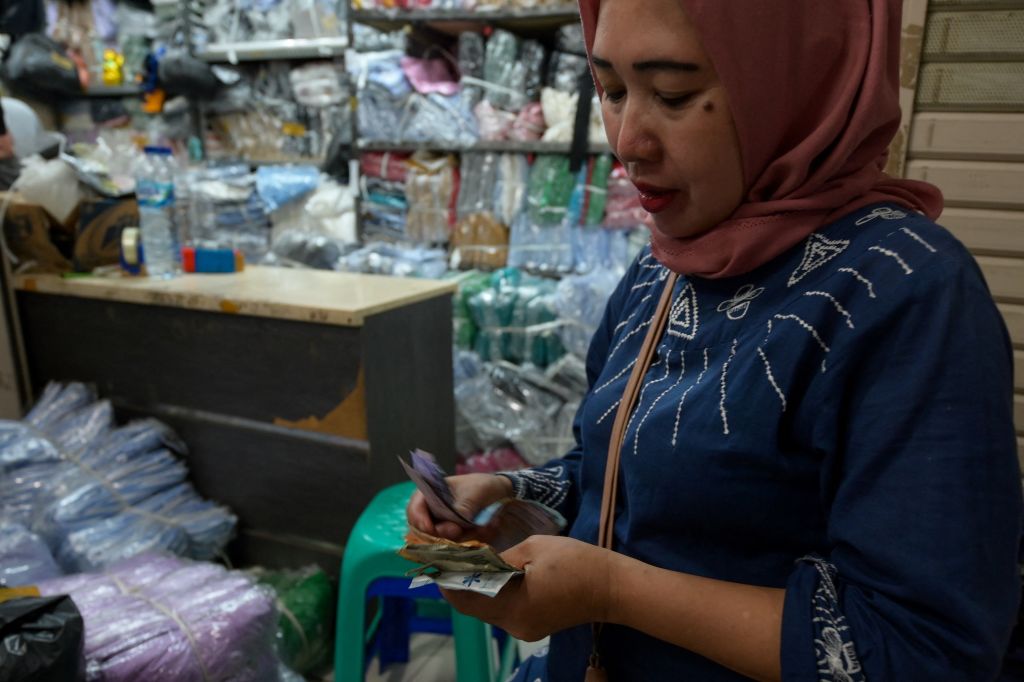 Một người phụ nữ đếm số tiền kiếm được tại chợ Tanah Abang ở Jakarta, Indonesia hôm 27/09/2023. (Ảnh: Bay Ismoyo/AFP qua Getty Images)