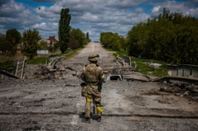 Một người lính thuộc đơn vị lực lượng đặc biệt Kraken của Ukraine quan sát khu vực tại một cây cầu bị hư hại trên con đường gần làng Rus'ka Lozova, phía bắc Kharkiv, hôm 16/05/2022. (Ảnh: Dimitar Dilkoff/AFP qua Getty Images)