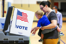 Một cử tri cùng con bỏ phiếu trong cuộc bầu cử sơ bộ giữa kỳ tại một điểm bỏ phiếu trong Trường tiểu học Rose Hill ở Alexandria, Virginia, vào ngày 21/06/2022. (Ảnh: Alex Wong/Getty Images)