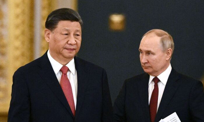 Tổng thống Nga Vladimir Putin (bên phải) và nhà lãnh đạo Trung Quốc Tập Cận Bình bước vào hội trường trong cuộc gặp tại Điện Kremlin ở Moscow, Nga, vào ngày 21/03/2023. (Ảnh: Alexey Maishev/Sputnik/AFP qua Getty Images)