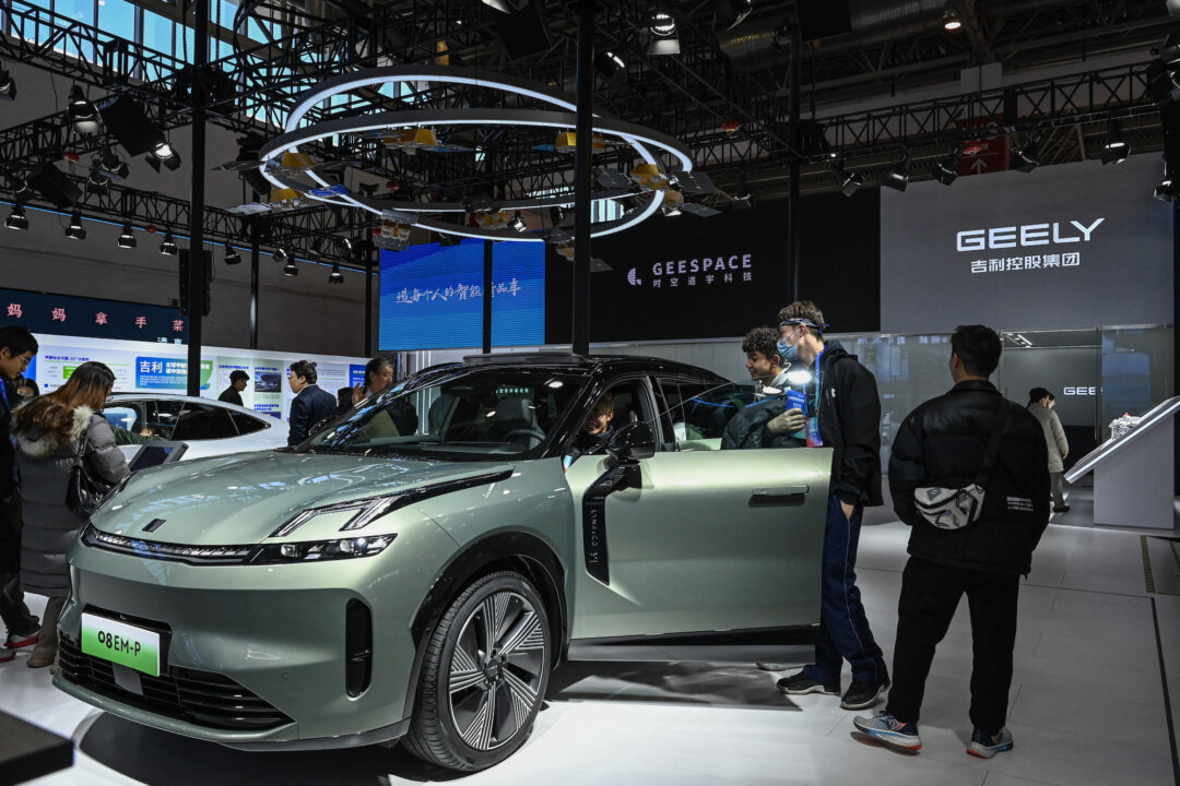 Người dân ngồi thử xe điện tại gian hàng của Geely trong Triển lãm Chuỗi cung ứng Quốc tế của Trung Quốc tại Bắc Kinh vào ngày 01/12/2023. (Ảnh: Jade Gao/AFP qua Getty Images)