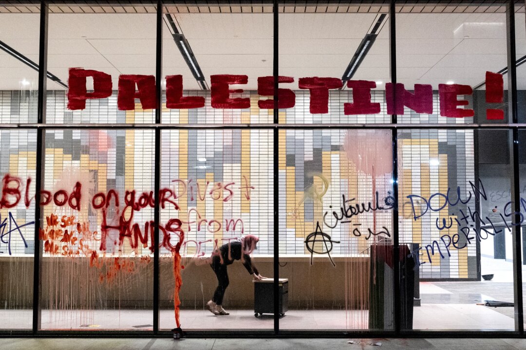 Một người biểu tình ủng hộ Palestine đẩy một chiếc tủ văn phòng nhỏ để sử dụng làm rào chắn tạm thời xung quanh Tòa nhà Dịch vụ Sinh viên của trường Đại học Tiểu bang California ở Los Angeles hôm 12/06/2024. (Ảnh: Etienne Laurent/AFP qua Getty Images)