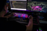 Một thành viên của nhóm tin tặc Red Hacker Alliance từ chối cung cấp tên thật đang sử dụng một trang web theo dõi các cuộc tấn công mạng toàn cầu trên máy điện toán của mình tại văn phòng ở Đông Quản, tỉnh Quảng Đông, Trung Quốc, vào ngày 04/08/2020. (Ảnh: Nicolas Asfouri/AFP qua Getty Images)