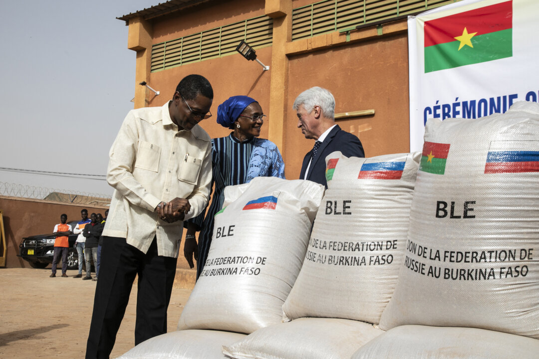 Ngoại trưởng Burkina Faso Karamoko Jean-Marie Traore (trái), Bộ trưởng Đoàn kết, Hành động Nhân đạo, Hòa giải quốc gia, Giới tính và Gia đình của Burkina Faso Nandy Some-Diallo (giữa) và đại sứ Nga tại Burkina Faso Aleksei Saltykov (phải) nói chuyện bên cạnh những bao lúa mì Nga quyên góp cho Burkina Faso ở Ouagadougou hôm 26/01/2024. (Ảnh: Fanny Noaro-Kabre/AFP qua Getty Images)