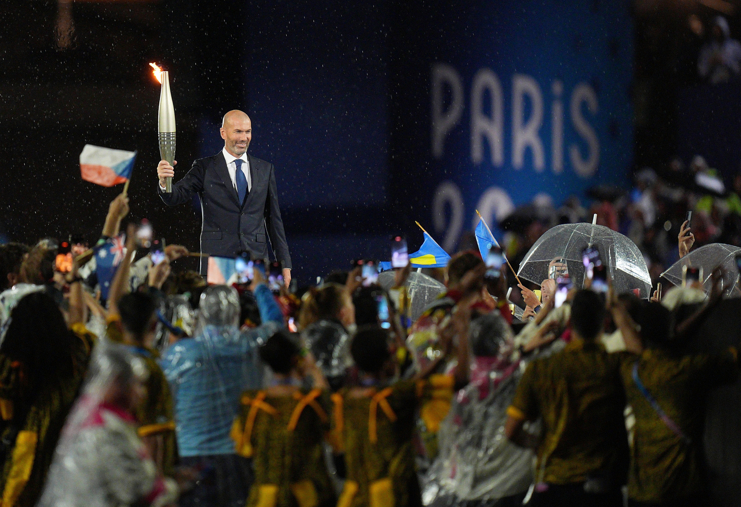 Cựu cầu thủ bóng đá Pháp Zinedine Zidane cầm ngọn đuốc Olympic trong lễ khai mạc Thế vận hội Olympic Paris 2024 tại Paris, Pháp, hôm 26/07/2024. (Ảnh: Xu Chang/Pool/Getty Images)