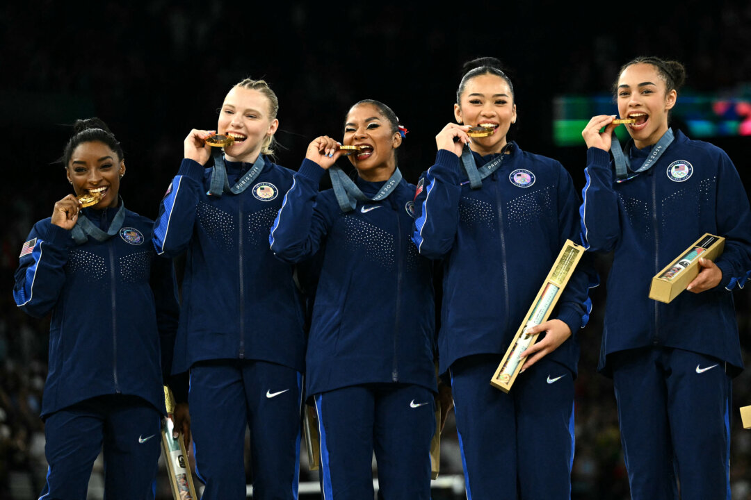 Cô Simone Biles (trái) và đồng đội của đội tuyển Hoa Kỳ chụp hình với huy chương vàng trong lễ trao giải cho trận chung kết đồng đội nữ môn thể dục dụng cụ nghệ thuật trong Thế vận hội Paris 2024, tại Nhà thi đấu Bercy ở Paris, hôm 30/07/2024. (Ảnh của Lionel Bonaventure/AFP)
